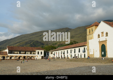 La piazza in ciottoli di Plaza Mayor in Villa de Leyva in Colombia, circondato da edifici coloniali e una chiesa parrocchiale Foto Stock