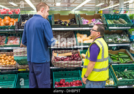 Newton Abbot, Devon, Inghilterra. Due elementi maschio del personale sul luogo di lavoro in Tesco Tescos supermercato. Foto Stock