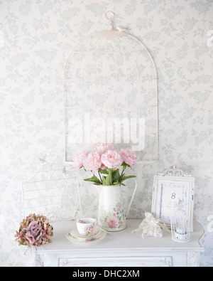 Un tavolino con brocca di rosa le peonie e ornamenti per la Cina Foto Stock