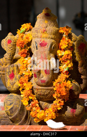 Sun basking stone carving (murthi) delle rotte tusked Signore Ganesh, l'elefante Dio, il dispositivo di rimozione di ostacoli e scrittore. Foto Stock