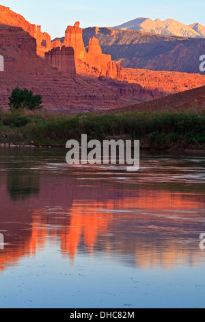 Le Torri di Fisher parzialmente illuminata dal sole del tardo pomeriggio si riflette nel fiume Colorado vicino a Moab,Utah Foto Stock