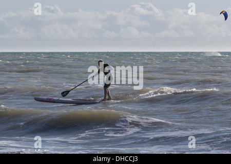 Paddleboard surfer a Bournemouth Beach vicino al molo di Bournemouth, Inghilterra Foto Stock