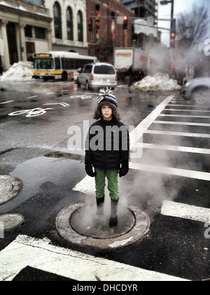 Ragazzo in piedi sul Steamy Chiusino in inverno Foto Stock