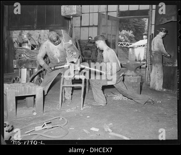 Woodrow agnello (sinistra) e Cyrus Williams rivetto una ferrovia frag su un basamento in una macchina negozio presso la miniera. Koppers... 540924 Foto Stock