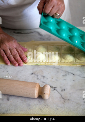 La donna la preparazione di ravioli freschi di pacchi Foto Stock