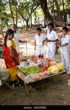 Rural Indian School boys di fronte ad un negozio di dolciumi presso il loro villaggio di alta scuola. Andhra Pradesh, India Foto Stock