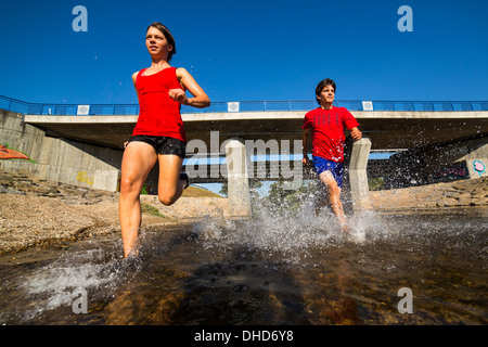 Germania Baden-Wuerttemberg, Winterbach, atletica giovane uomo e la giovane donna che corre attraverso rem river Foto Stock