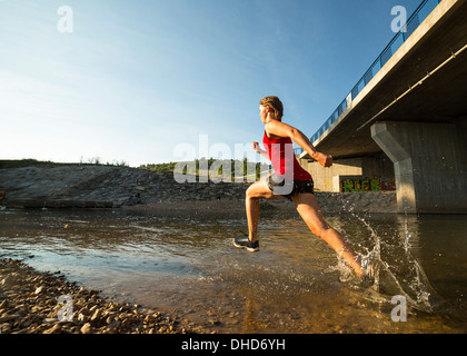 Germania Baden-Wuerttemberg, Winterbach, atletica giovane donna in esecuzione attraverso rem river Foto Stock