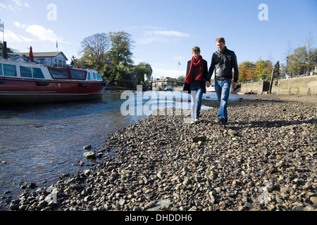Il fiume Tamigi Twickenham Riverside. Giovane / persone / a piedi camminando lungo la spiaggia / riverbank banca / letto molto durante la bassa marea, REGNO UNITO Foto Stock