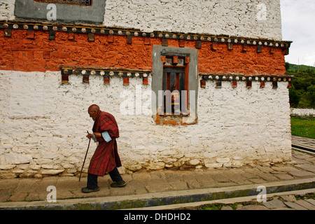 Buddisti di cerchiare la costruzione,spingendo sulle ruote della preghiera,i monaci buddisti recitando preghiere in questo antico monastero,Bumthang Foto Stock