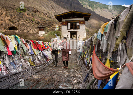 Il Bhutan, Paro Valley, il turista femminile ha aiutato oltre Tachog Lhakang Dzong bridge, dalla guida Foto Stock