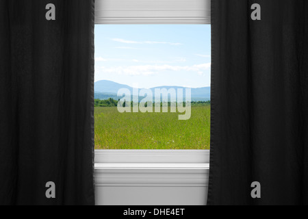 Estate paesaggio visto attraverso la finestra con tende nere. Foto Stock