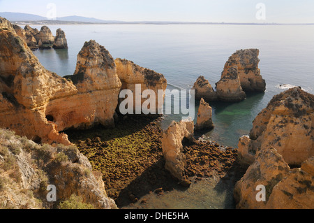 Weathered scogliere di arenaria e pile di mare a Ponta da Piedade, Lagos, Algarve, Portogallo. Foto Stock