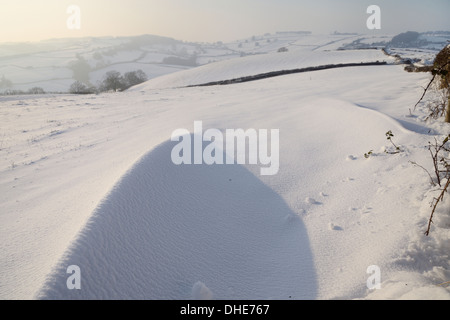 Snow Drift sulla collina esposta pascoli nel tardo pomeriggio di luce, Tadwick, vasca da bagno e nel nord-est Somerset, Regno Unito, gennaio. Foto Stock