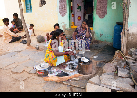 Donna indiana che dosa di cottura per le persone al di fuori di un villaggio rurale casa. Andhra Pradesh, India Foto Stock