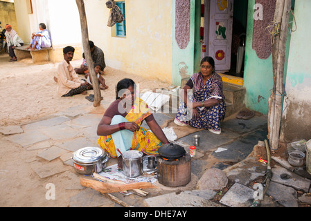 Donna indiana che dosa di cottura per le persone al di fuori di un villaggio rurale casa. Andhra Pradesh, India Foto Stock