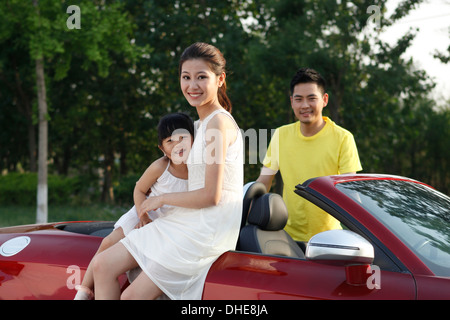 Una famiglia felice di tre guidando vetture convertibili Foto Stock