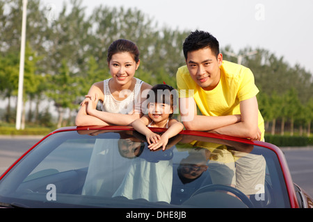 Una famiglia felice di tre guidando vetture convertibili Foto Stock