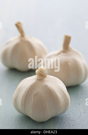 Tre bulbi di aglio bianco su un piano di un tavolo. Foto Stock