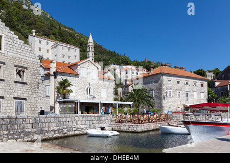 Perast harbour con caffè e barche ormeggiate fino, Baia di Kotor, Sito Patrimonio Mondiale dell'UNESCO, Montenegro, Europa Foto Stock