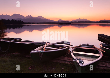 Barche a remi sul Lago Hopfensee al tramonto, vicino a Fussen, Allgau, Allgau Alpi, Baviera, Germania, Europa Foto Stock