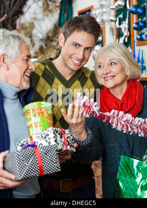 Uomo con i genitori Shopping nel negozio di Natale Foto Stock