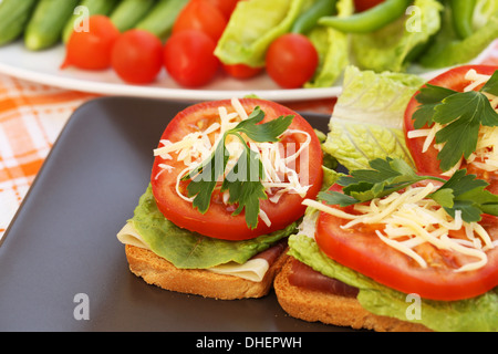 Panini con pancetta, lattuga, pomodoro e formaggio sulla piastra. Foto Stock