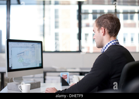 Uomo che utilizza il computer in ufficio Foto Stock