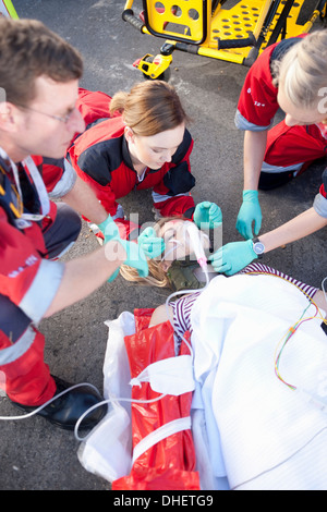 Tre i paramedici con il paziente sulla barella di indossare le maschere di ossigeno Foto Stock