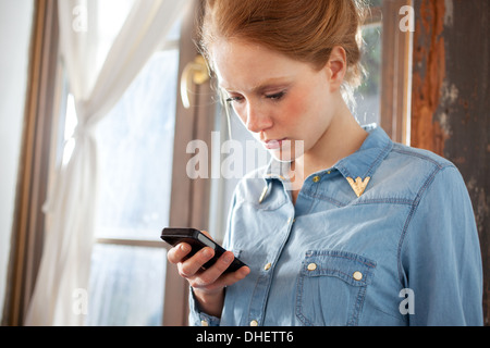 Giovane donna utilizza lo smartphone Foto Stock