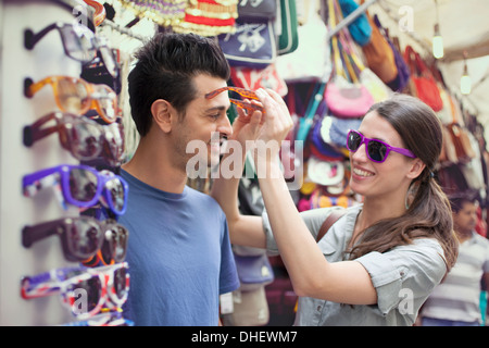 Coppia giovane cerca su occhiali da sole, il mercato di San Lorenzo, Firenze, Toscana, Italia Foto Stock