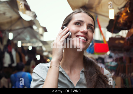 Giovane donna sul telefono cellulare, il mercato di San Lorenzo, Firenze, Toscana, Italia Foto Stock