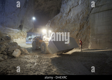 Lavoratore e escavatore in cava di marmo