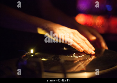 Close up DJ con le mani in mano la filatura in vinile in discoteca Foto Stock
