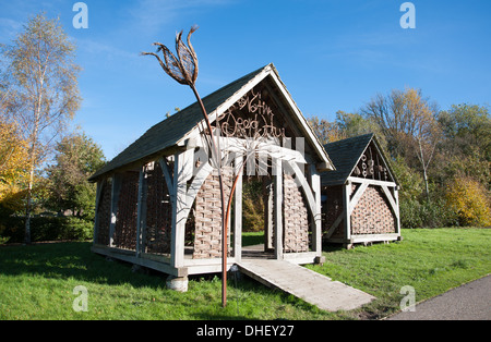 Donna che guarda le capanne educative del Native Seed Hub a Wakehurst nel West Sussex, che fa parte dei Kew Botanical Gardens Foto Stock