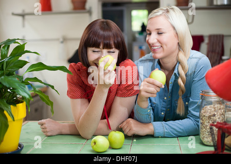 Amici di sesso femminile in cucina con le mele Foto Stock