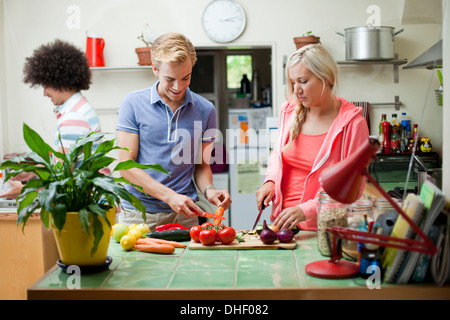 Flatmates preparare verdure in cucina Foto Stock