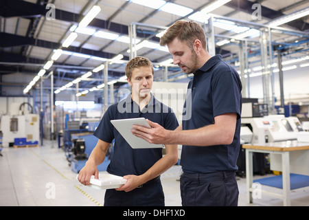 Lavoratori controllo ordine nella fabbrica di ingegneria Foto Stock