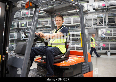 Carrello elevatore driver nel magazzino di ingegneria Foto Stock