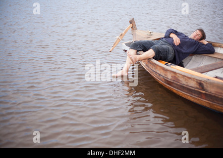 Uomo disteso in barca a remi, Wales, Regno Unito Foto Stock