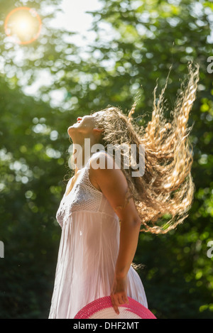 Ragazza adolescente indossando white sundress tossing capelli lunghi, Praga, Repubblica Ceca Foto Stock