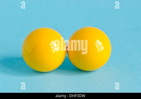 Due giallo biliardo palla su sfondo blu Foto Stock