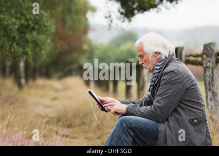 Senior uomo con tavoletta digitale Foto Stock