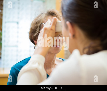 All'ottico optometrista esaminando Senior donna di Vision Foto Stock