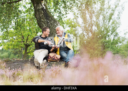 Padre e figlio adulto di bere il caffè dal pallone Foto Stock