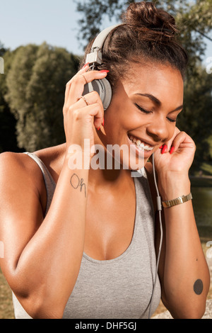 Giovane donna godendo di musica sul suo cuffie Foto Stock