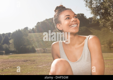 Felice giovane donna alla luce del sole in un parco