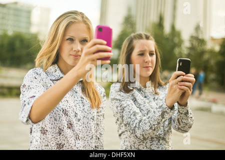 Due giovani donne che assumono autoritratti sul telefono cellulare Foto Stock