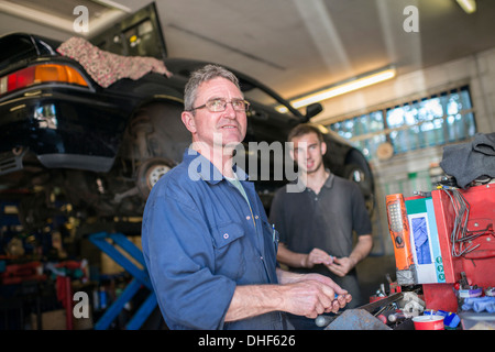Due meccanici in garage Foto Stock