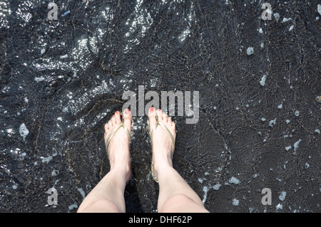 Piedi in mare vulcano attivo nero cenere vulcanica di sabbia di mare Foto Stock